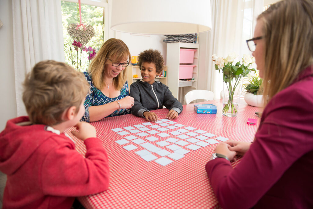 Gezinshuisouder met kinderen aan tafel